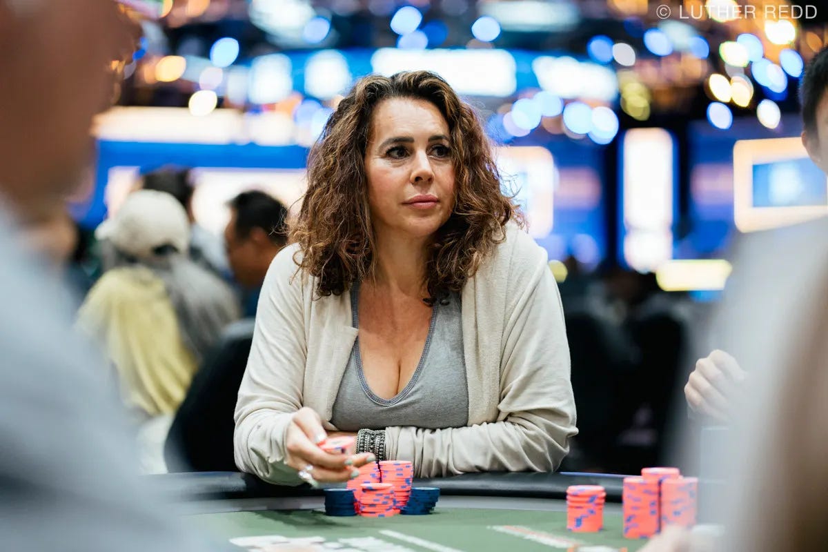 Ashira Lavine, the high-performing poker athlete, with dark shoulder length hair, grey top and white sweater. The background is blurred with lights behind her head. Photo by Luther Redd of PokerNews.com. Ashira Lavine, the high-performing poker athlete, with dark shoulder length hair, grey top and white sweater. The background is blurred with lights behind her head. Photo by Luther Redd of PokerNews.com.