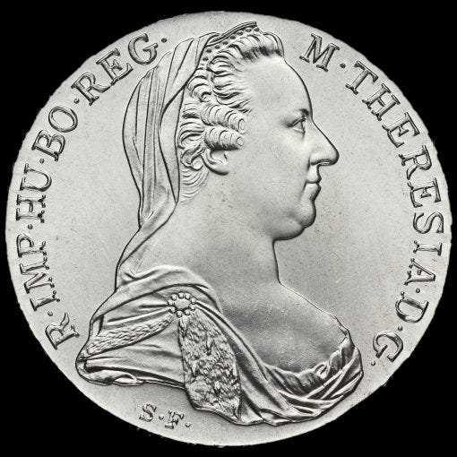 A high-resolution studio photograph of the obverse side of a silver Maria Theresa Thaler coin. The coin features the right-facing profile of Empress Maria Theresa, wearing a widow's veil and a brocaded dress. The Latin inscription along the border reads M. THERESIA D. G. R. IMP. HU. BO. REG., and the initials S. F. are visible at the base of the bust.