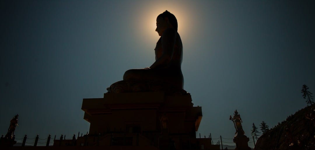 silhouette photo of Buddha statue silhouette photo of Buddha statue