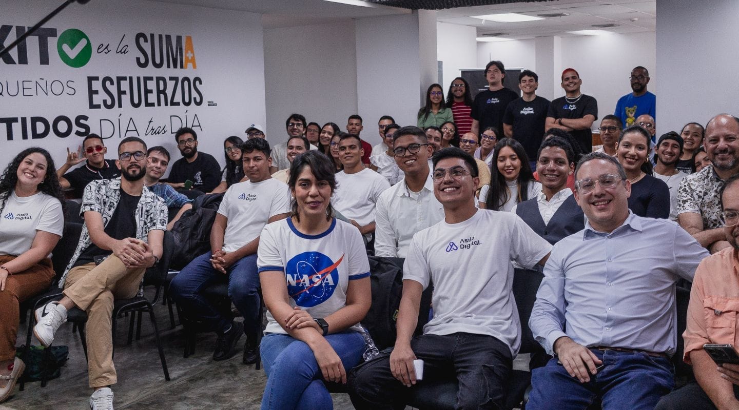 Un grupo de personas reunido en un salón de eventos.