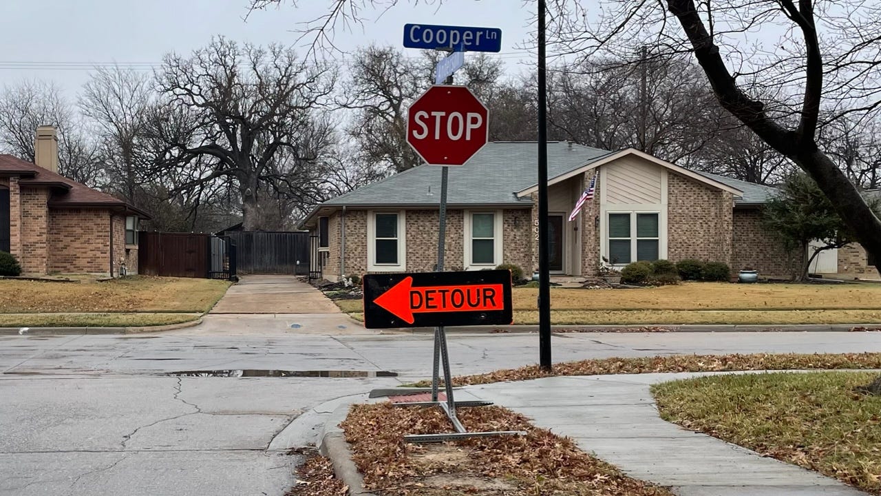 A "DETOUR" sign featuring an orange arrow below a traditional "STOP" sign