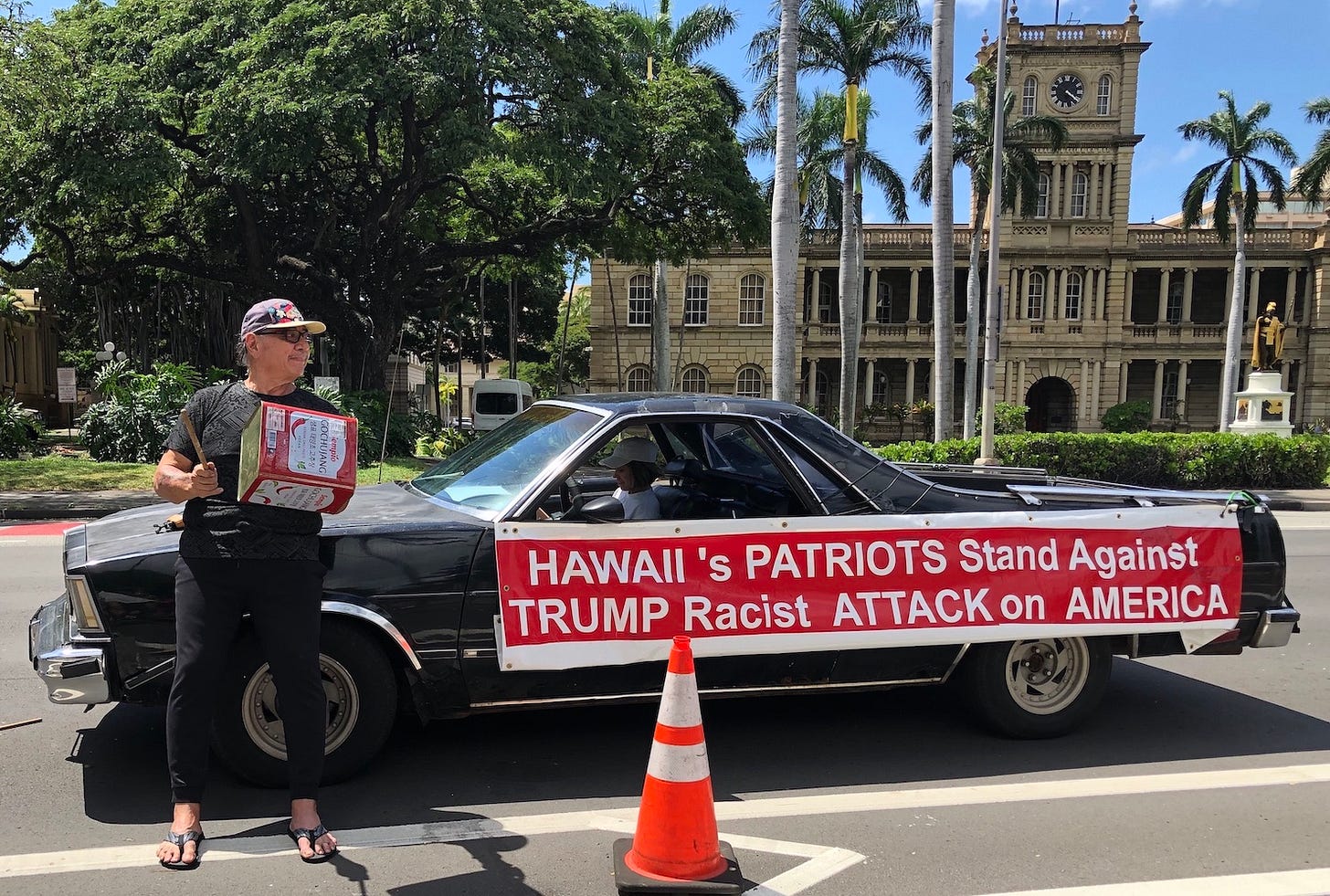 Car with sign that says Hawaii's patriots stand against Trump racist attack on America.