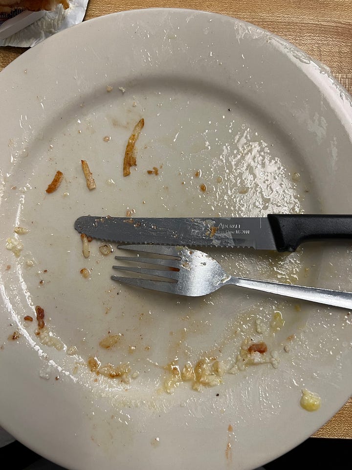 two plates of eggs, sausage, hash browns, and grits