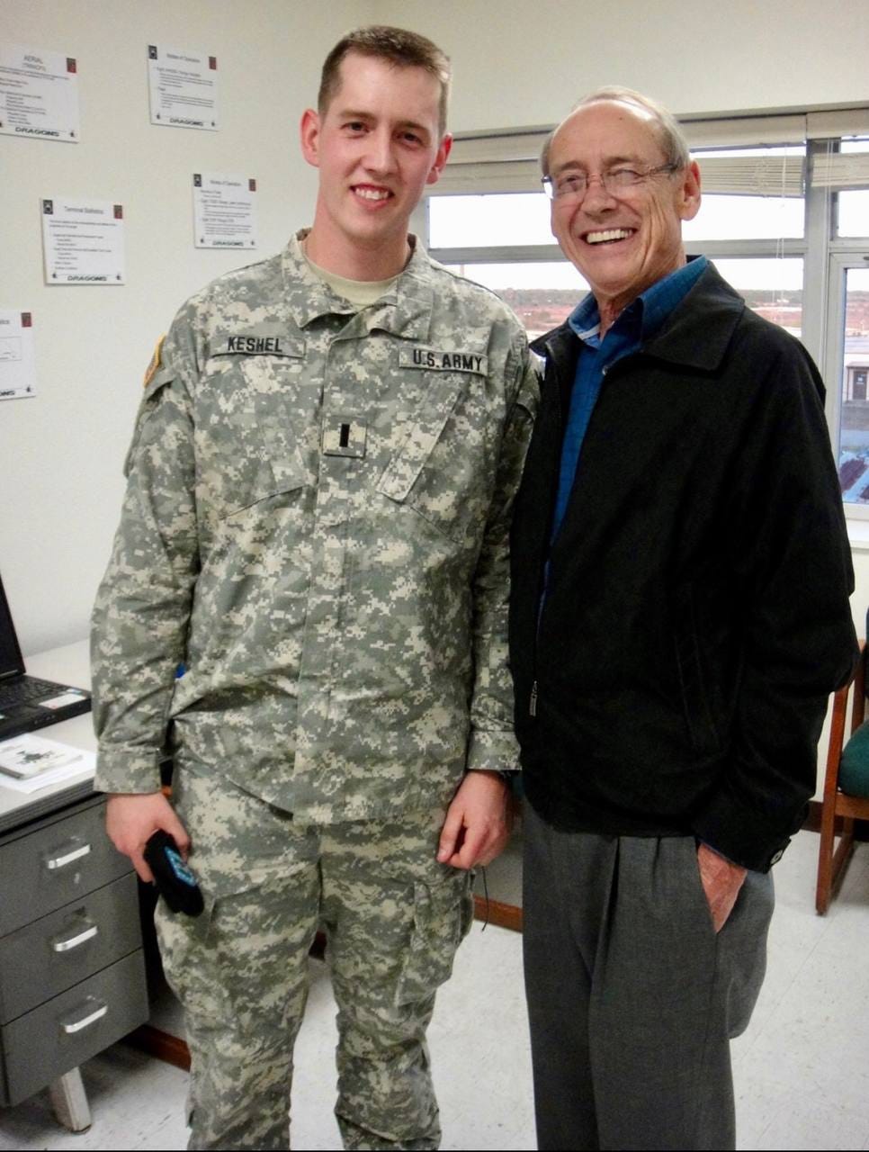 A person standing next to a soldier

Description automatically generated