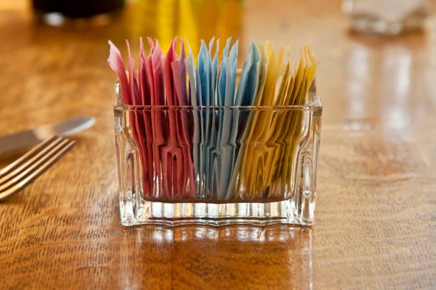 artificial sweetener selection on a oak table - artificial food color stock pictures, royalty-free photos & images