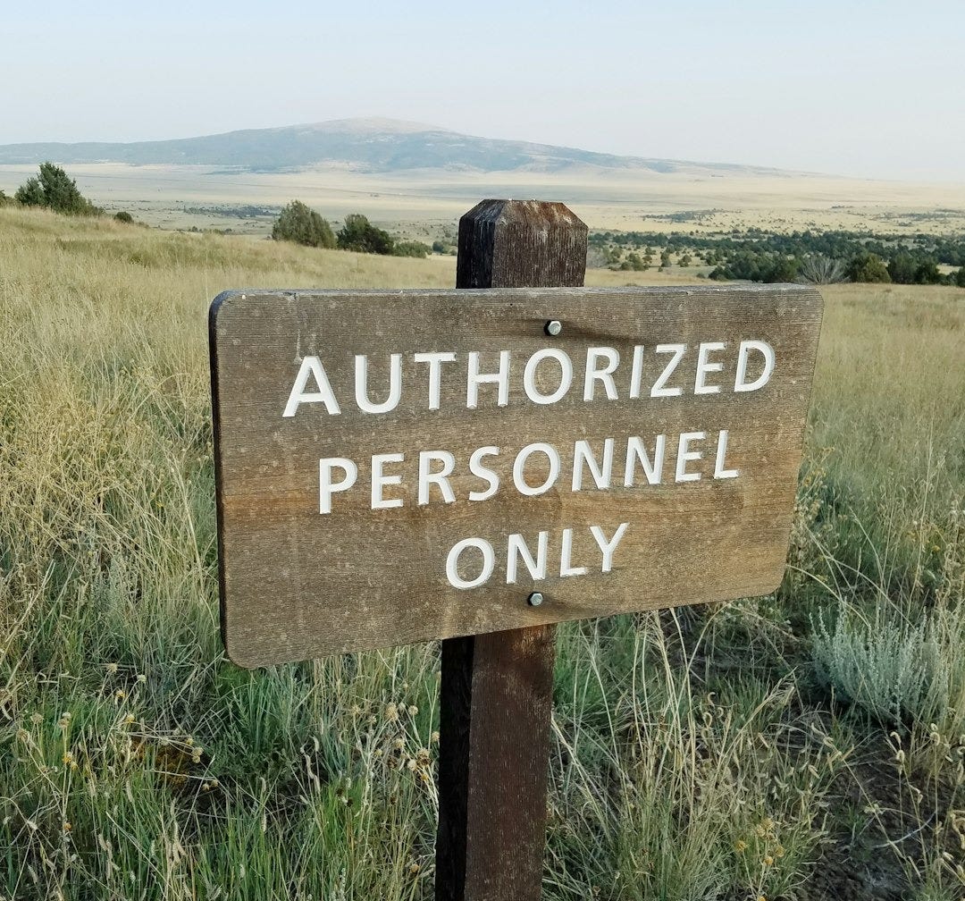 brown wooden signage on green grass field during daytime