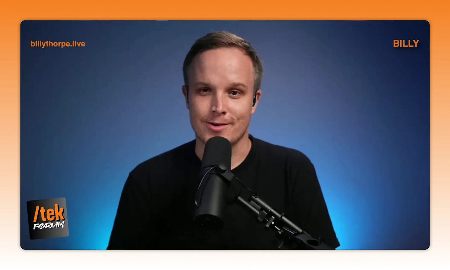 Presenter smiling at camera while speaking into a microphone with blue background Presenter smiling at camera while speaking into a microphone with blue background