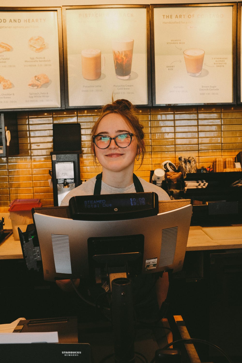 Starbucks barista smiling behind counter