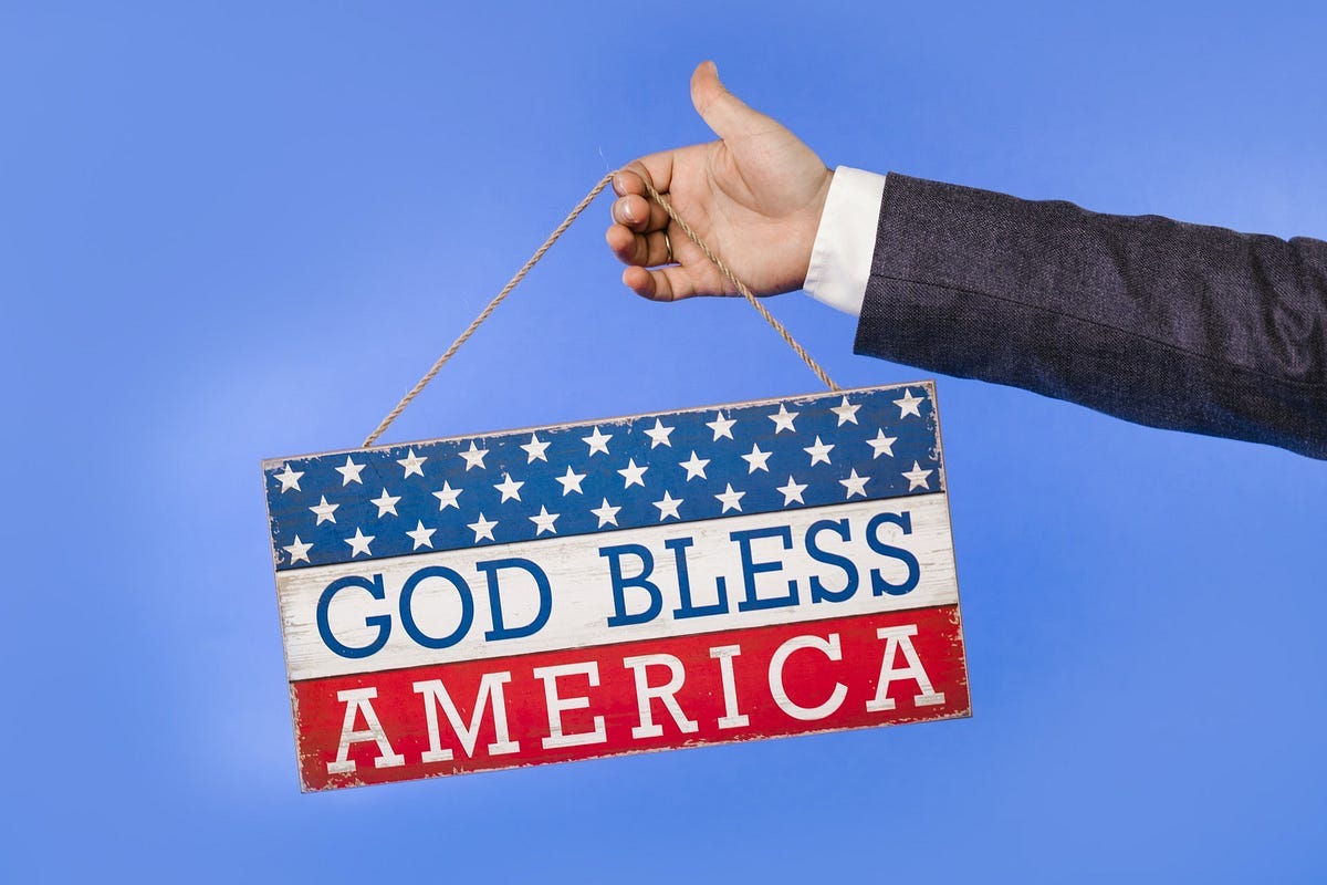 Arm holding a “God Bless America” red/white and blue poster