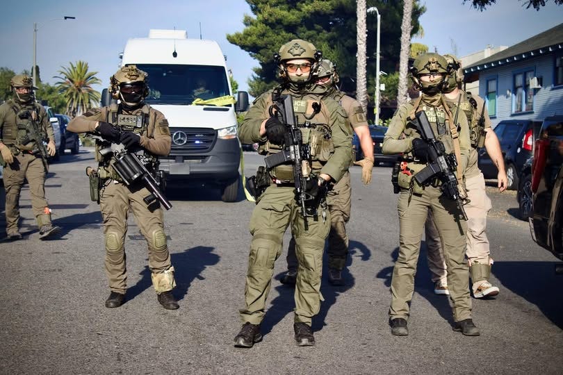 Four armed and dressed for combat ice agents face the camera