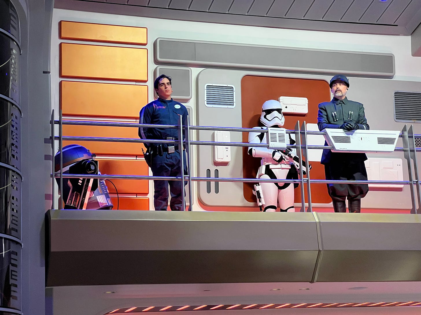 A droid, human (Sammie), stormtrooper, and Croy on the raised atrium