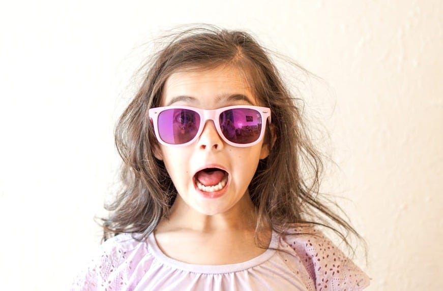 girl in white and purple floral crew neck shirt wearing blue framed sunglasses girl in white and purple floral crew neck shirt wearing blue framed sunglasses