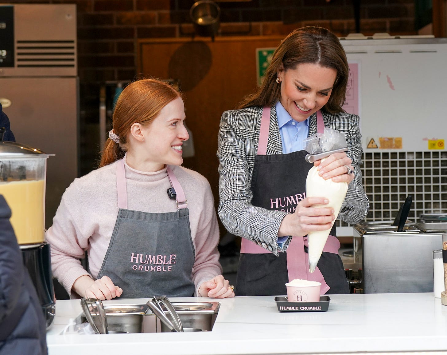 Princess Catherine icing a humble crumble next to a member of staff