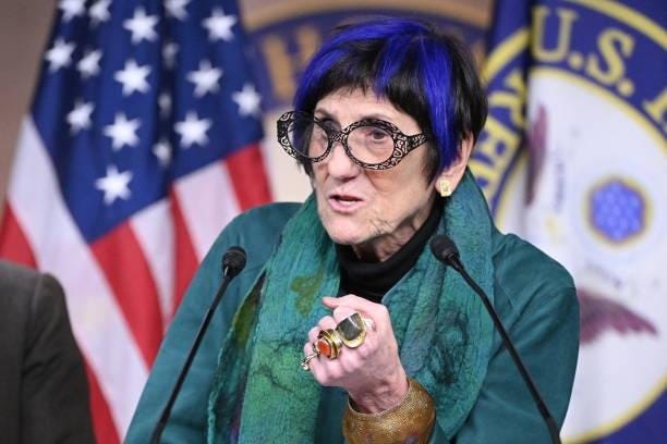 A person with blue hair and glasses speaking into microphones

AI-generated content may be incorrect.