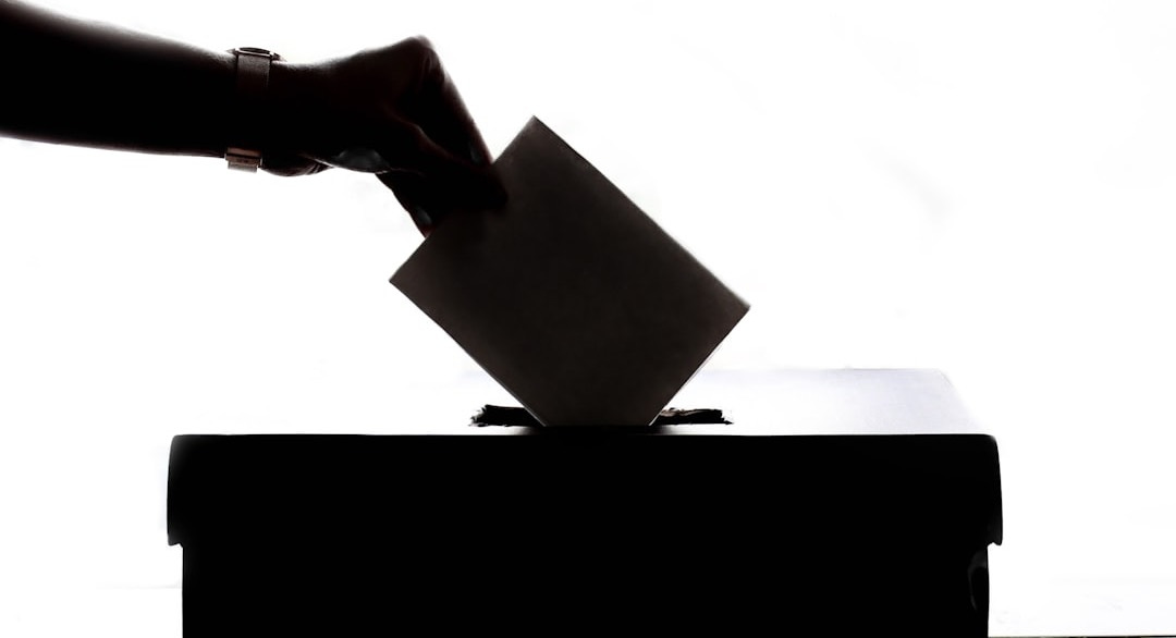 a person is casting a vote into a box
