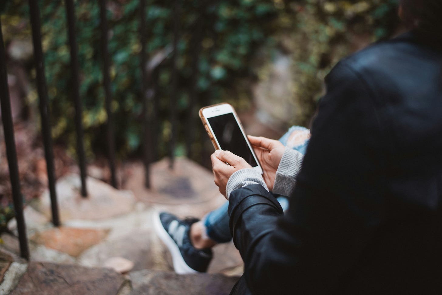 A younger person sits looking at their phone.