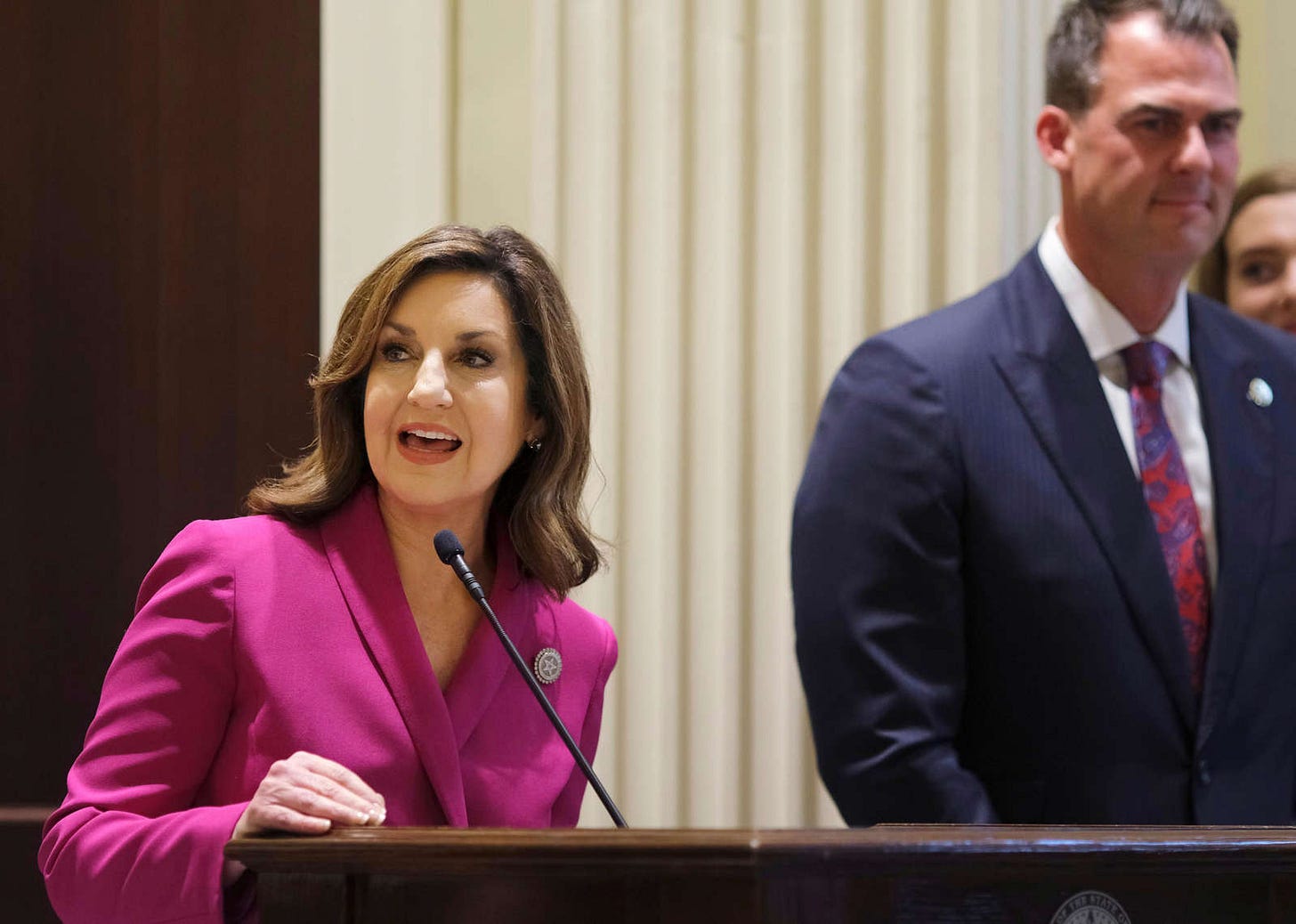 Kevin Stitt et al. wearing a suit and tie: Joy Hofmeister, state schools superintendent, speaks during a news event.