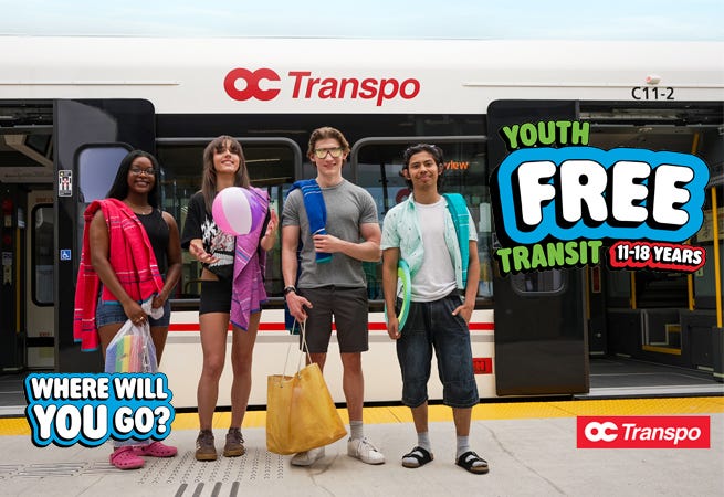 Four teens stand on the platform at a train station. An OC Transpo train is in the background