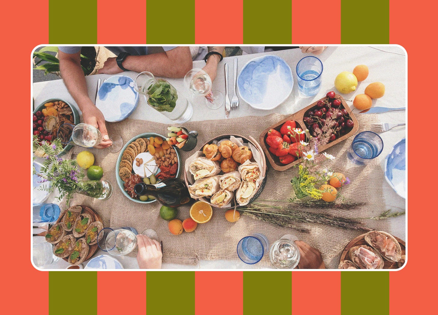 A photograph of an outdoor table setting set in the center of a coral and olive green striped background