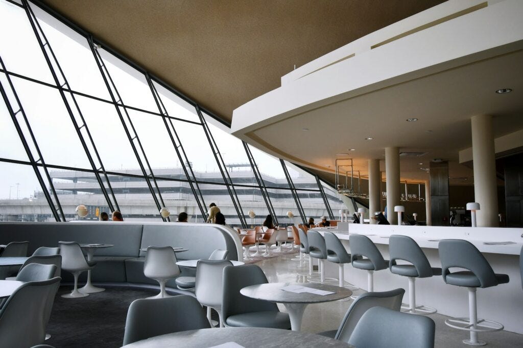 people sitting on white chairs inside building people sitting on white chairs inside building
