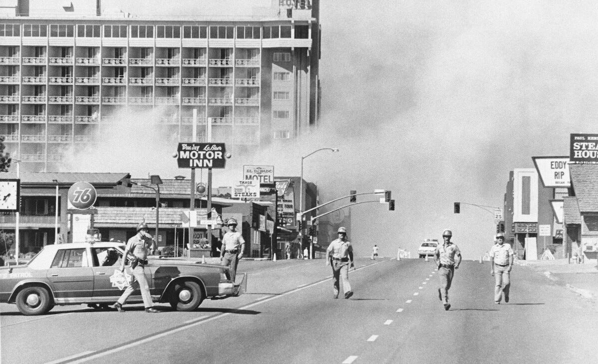 Police and sheriff's deputies rush towards the crowd on Highway 50 in South Lake Tahoe after a powerful bomb blast devastated the side of Harvey's Resort Hotel on August 27, 1980. Miraculously, no one was injured in the incident.