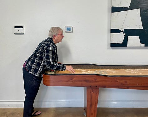 photo of Jill getting the shuffleboard ready for play and her and i playing.