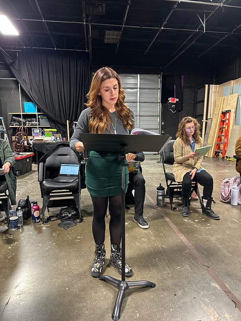 Actors reading a play in a theater.