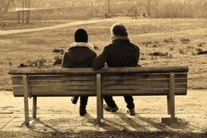 two people on a park bench talking
