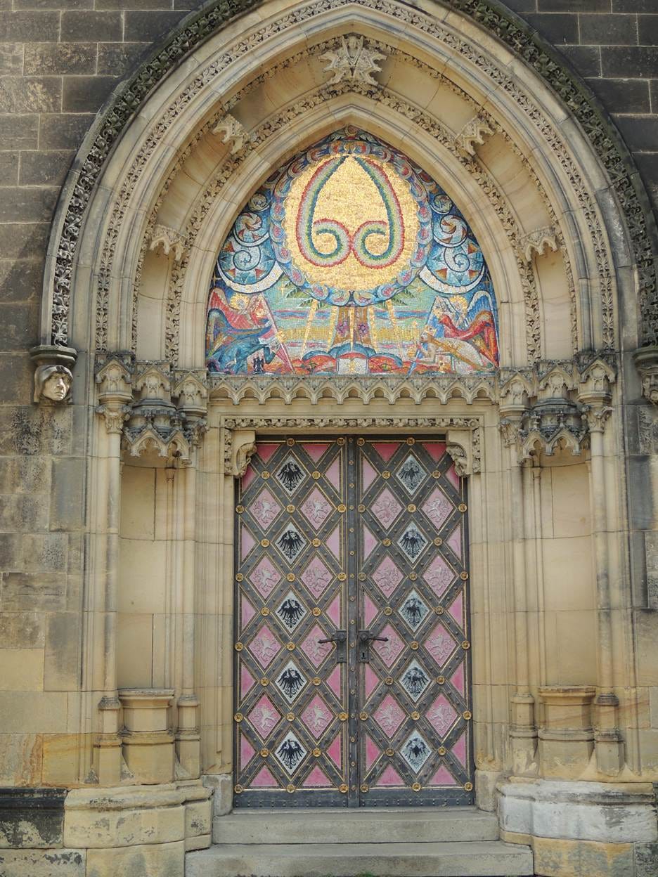 A ornate doorway with mosaic over the door

AI-generated content may be incorrect.