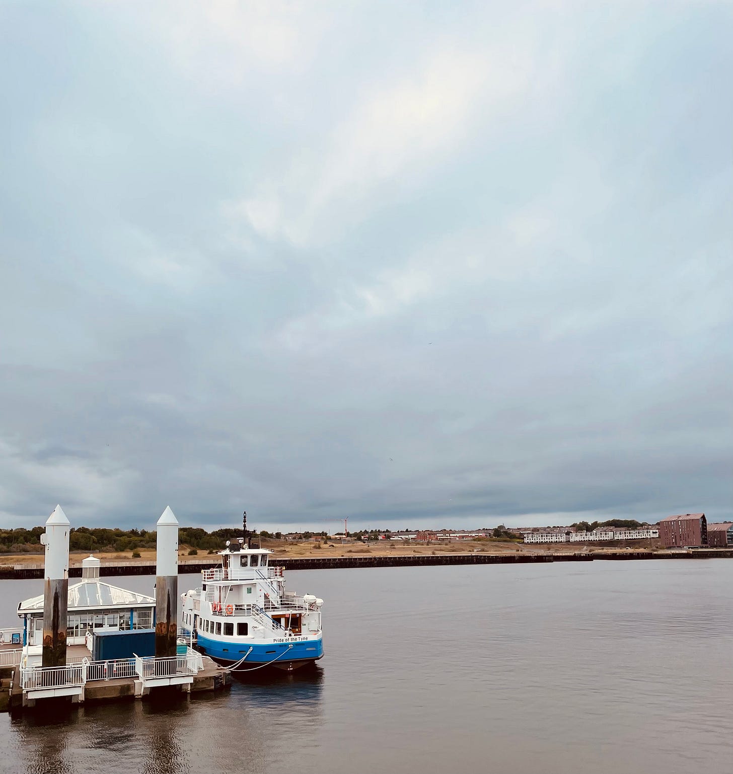A lot of faintly blue sky, a lot of faintly grey water, and in the middle, the bright blue Shields Ferry tied up at the quay.