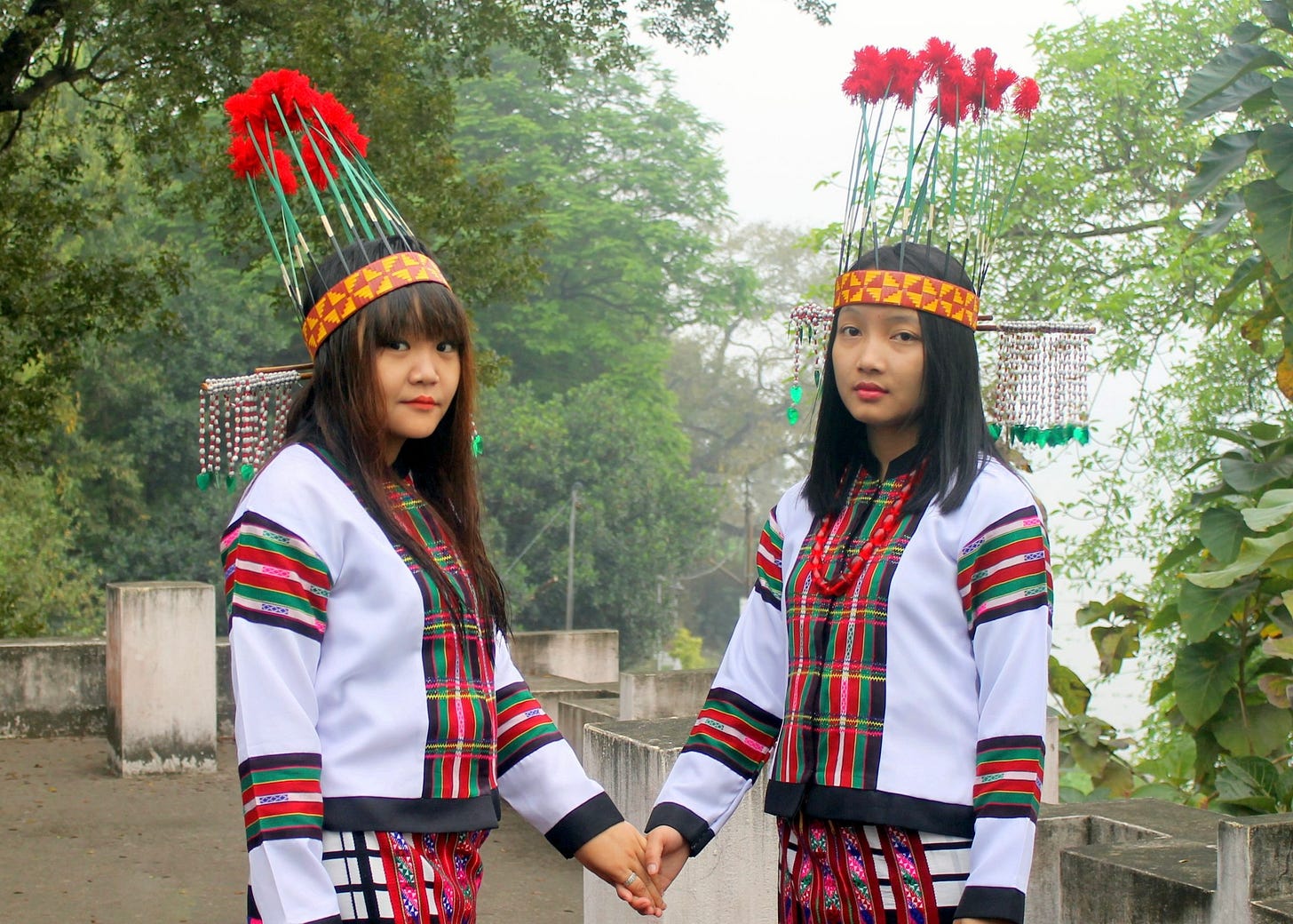 Two young Mizo women dressed in traditional Mizo clothing, and standing together. Photo by Lawrence S