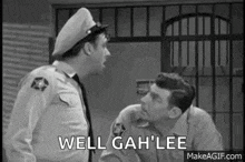 two police officers are standing next to each other in a jail cell . two police officers are standing next to each other in a jail cell .