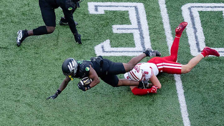 Wisconsin Badgers linebacker Mason Posa (8) tackles an Oregon Ducks player during a game at Autzen Stadium. Wisconsin Badgers linebacker Mason Posa (8) tackles an Oregon Ducks player during a game at Autzen Stadium.