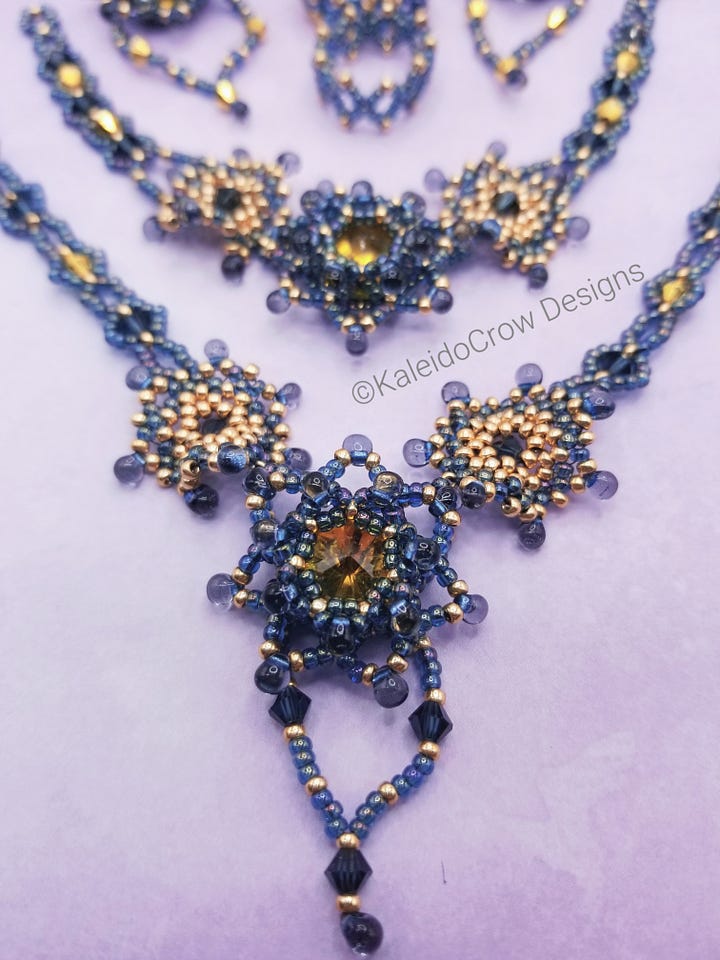 Photos of a beaded necklace, bracelet, earrings and rings in a gray blue color with gold color accents.