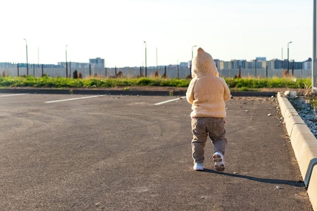 A small child runs in the parking lot against the setting sun | Premium  Photo