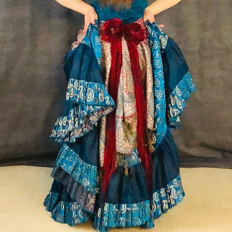 A variety of skirts bustled in the back with flowers and yarn dangles creating a centerpiece between the ruffles.