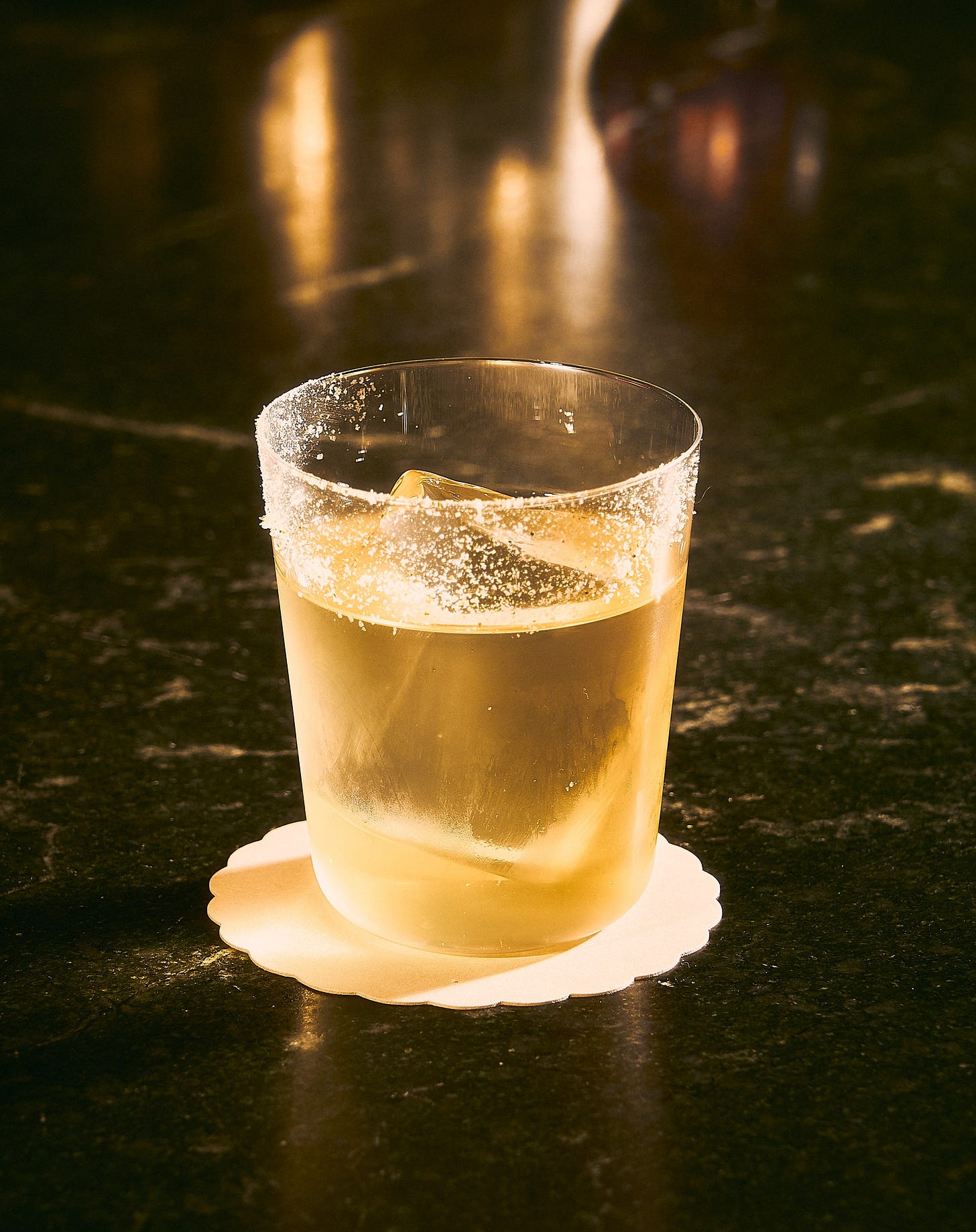 Yellow hued cocktail on a rock in a class at Vandell Yellow hued cocktail on a rock in a class at Vandell