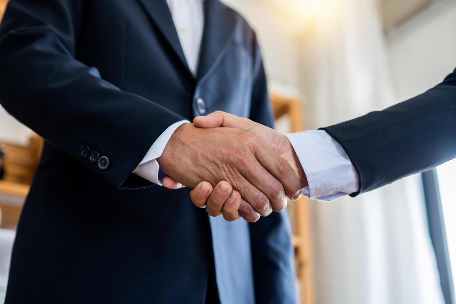 Two businessmen shake hands to seal a negotiation deal at work 1103229 ...