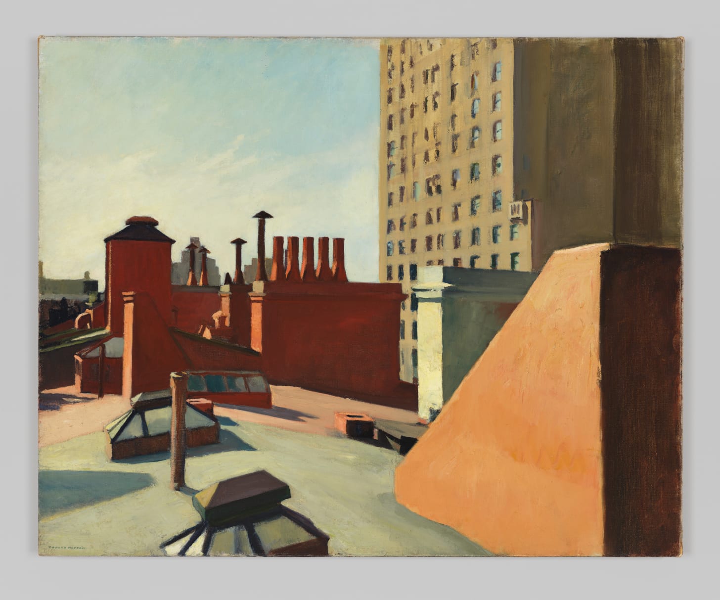 Rooftop scene with red chimneys and a tall building in the background under a clear sky.