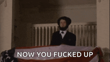 a man in a suit and tie is holding an american flag and says now you fucked up a man in a suit and tie is holding an american flag and says now you fucked up