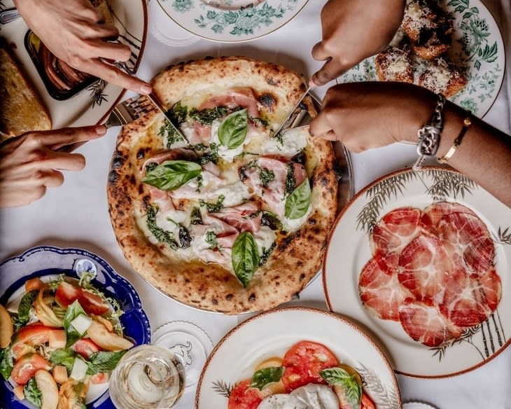 People tucking into pizza
