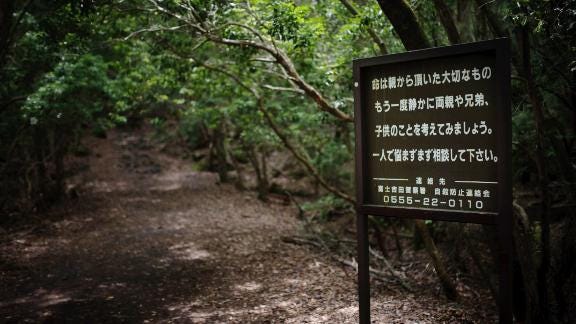 A sign at the entrance of the Aokigahara forest urges suicidal visitors to reach out for help.