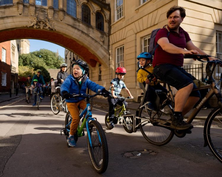 Children and their parents cycle together through the city.