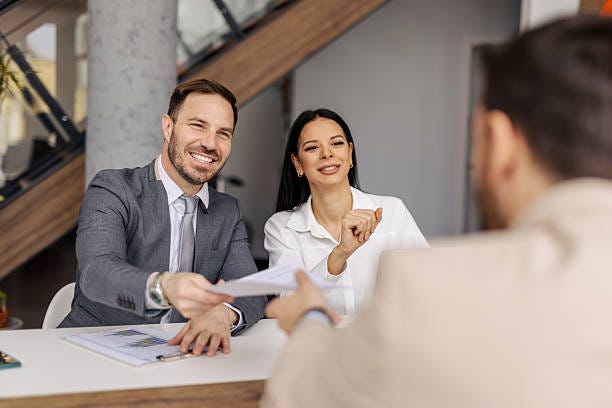 Group of professional data analysts sitting at corporate office and doing paperwork.