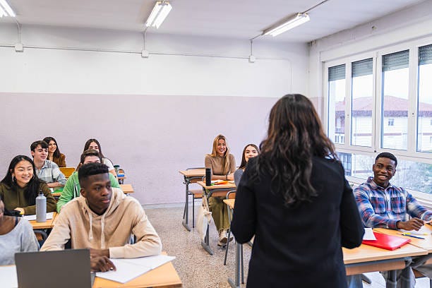 Teacher giving lesson to high school students in classroom