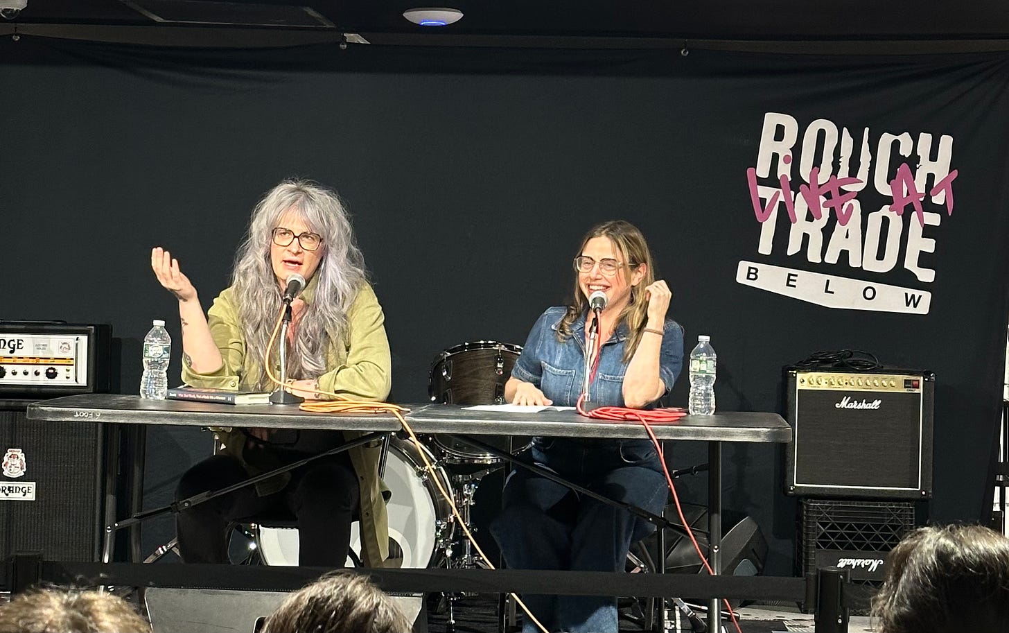 Niko and Maris sitting at a table at Rough Trade record store in Manhattan talking about Niko's book.