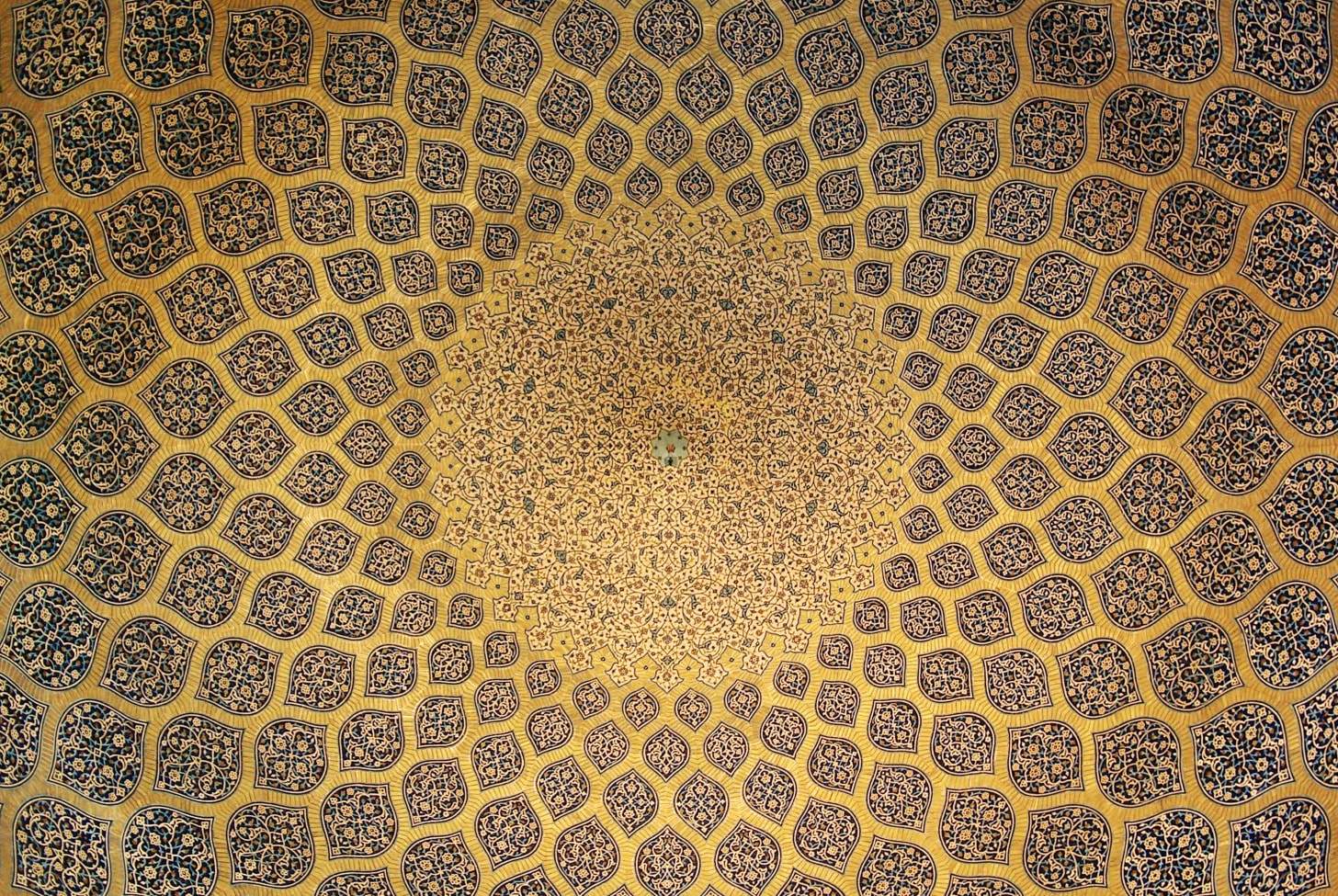 The interior of the dome which is inset with a network of lemon-shaped compartments, which increase in size as they descend from a formalised peacock at the pattern inlaid on plain stucco
