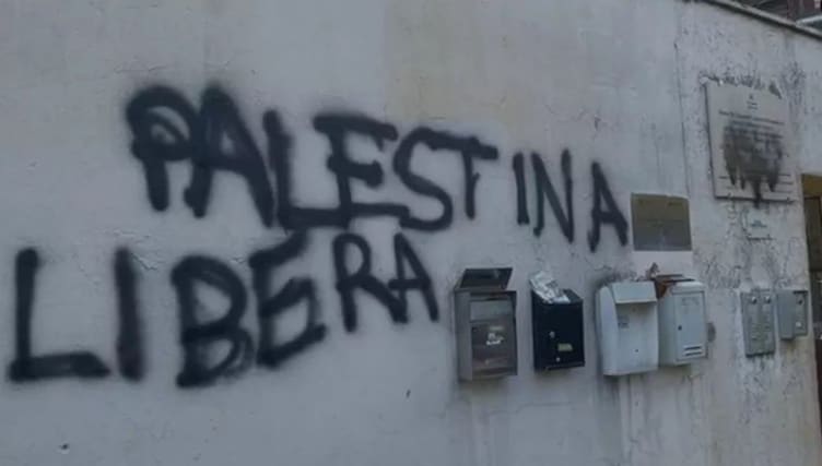 A wall with black spray paint on it

AI-generated content may be incorrect.