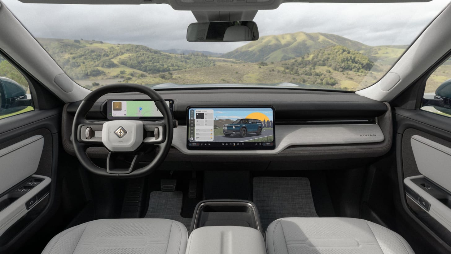 vehicle interior with steering wheel, digital instrument cluster, center touchscreen, light seats.