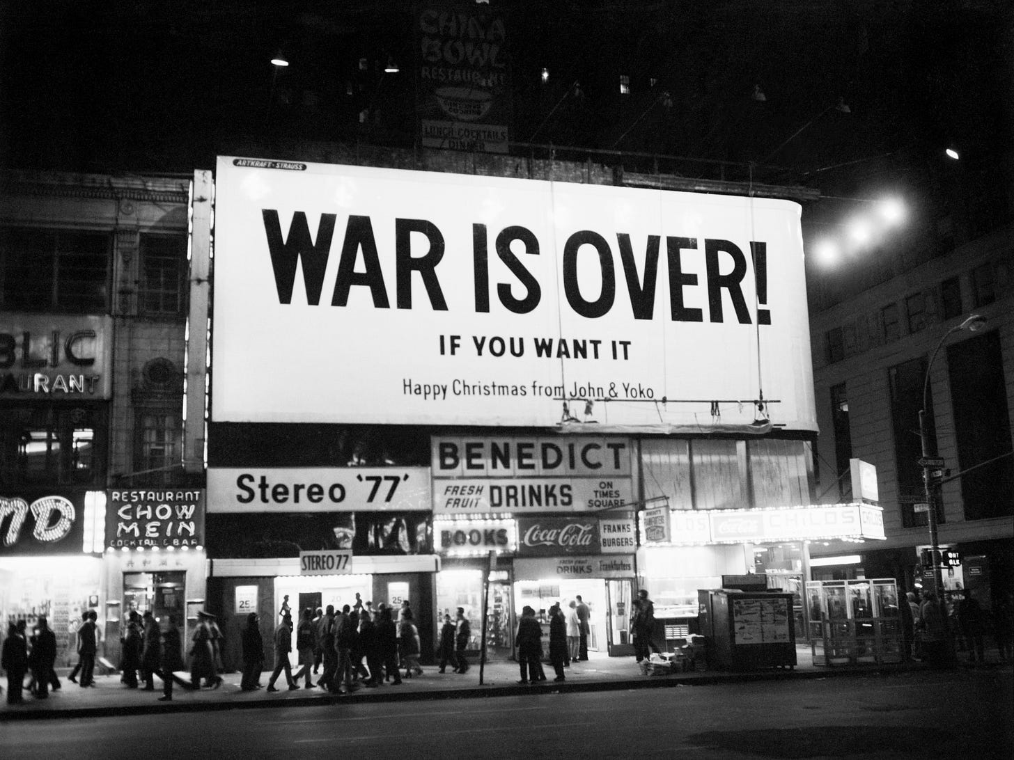 Black and white photograph of a large billboard in crowded Times Square, with large text that reads: “WAR IS OVER! IF YOU WANT IT - Happy Christmas from John & Yoko Black and white photograph of a large billboard in crowded Times Square, with large text that reads: “WAR IS OVER! IF YOU WANT IT - Happy Christmas from John & Yoko